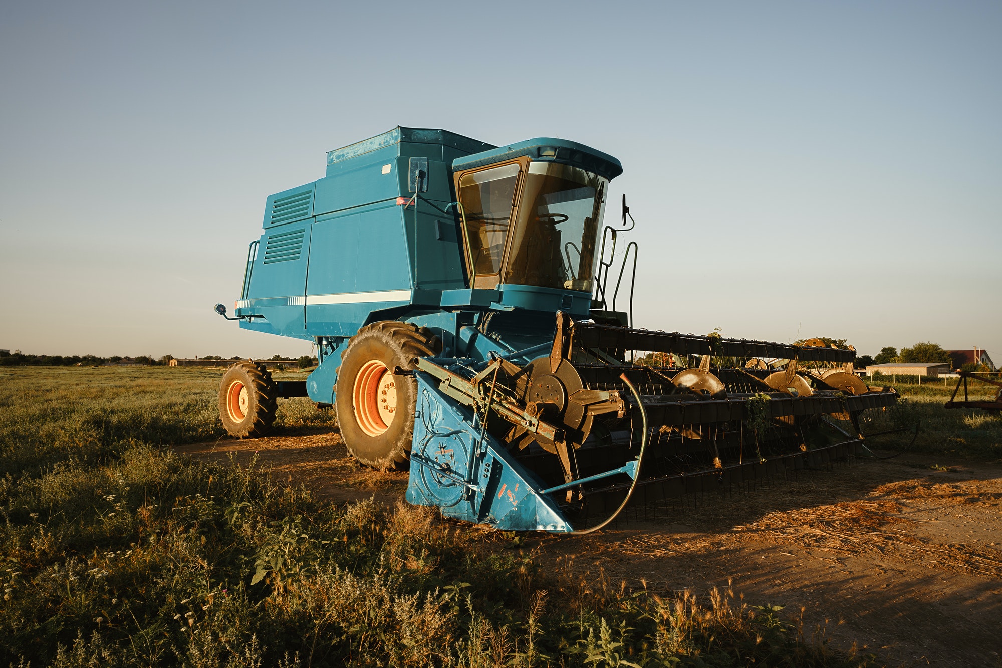 Blue combine harvester agriculture machine harvesting in a field