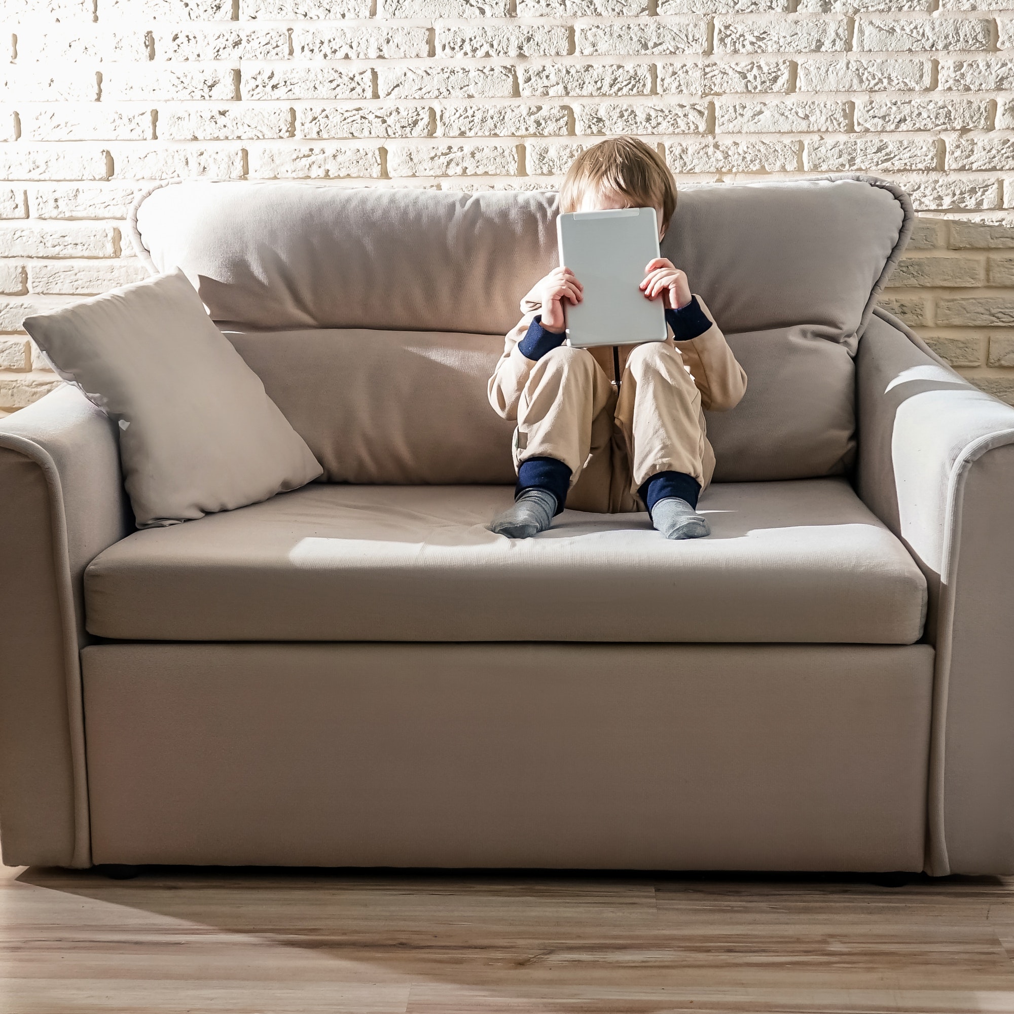 Kid use laptop sit on sofa